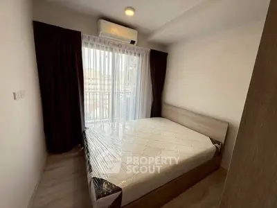 Cozy bedroom with natural light and modern air conditioning unit, perfect for relaxation.