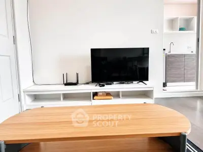 Modern living room with sleek TV setup and adjacent kitchen area.