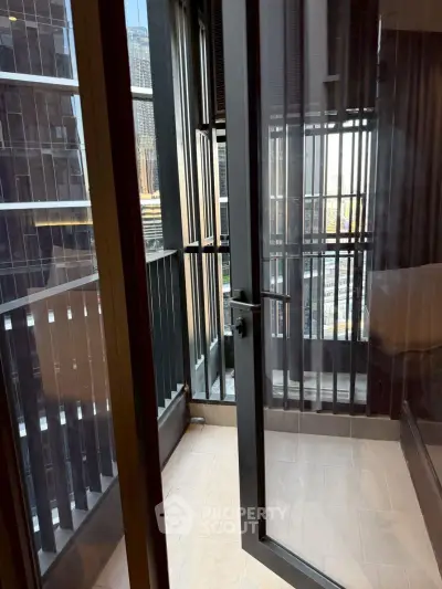Modern apartment balcony with city view and sleek glass door