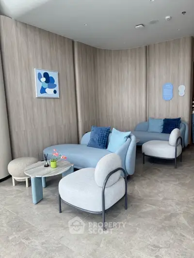 Modern living room with stylish blue and gray furniture, abstract wall art, and elegant decor.