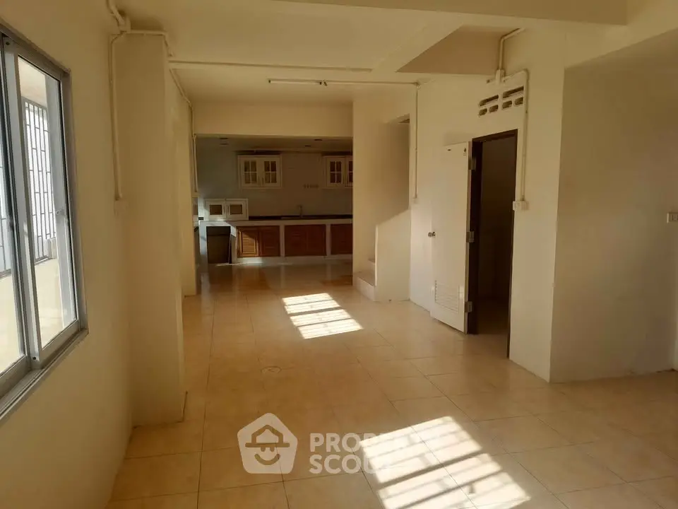 Spacious open-plan living area with tiled flooring and ample natural light, ideal for modern living.