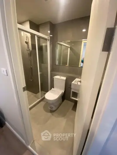 Modern bathroom with glass shower and sleek fixtures in a contemporary apartment.