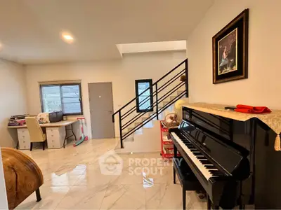 Spacious living room with elegant piano and modern staircase in a stylish home.