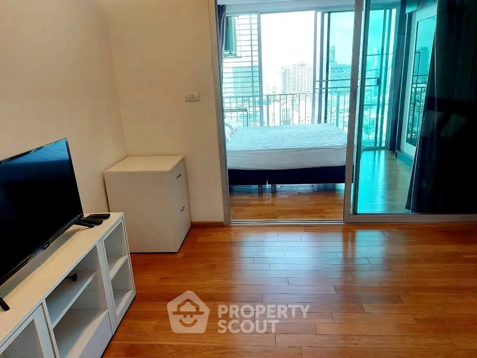 Modern apartment with wooden flooring and city view from the balcony, featuring a cozy bedroom and living area.