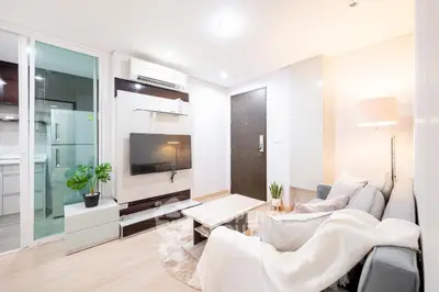 Modern living room with sleek furniture and stylish decor, featuring a cozy sofa and wall-mounted TV.