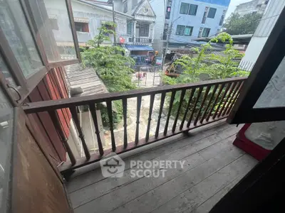 Charming wooden balcony with street view in urban setting, perfect for relaxation.