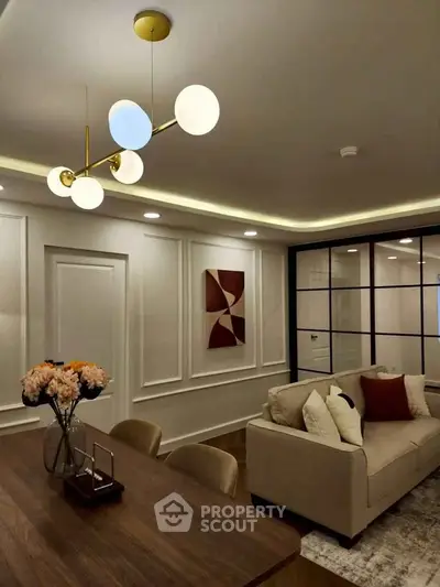 Elegant living room with modern lighting and stylish decor, featuring a cozy sofa and chic wall art.