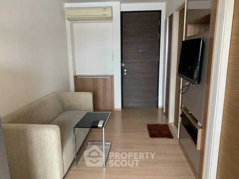 Cozy living room with modern sofa and wall-mounted TV in a stylish apartment.