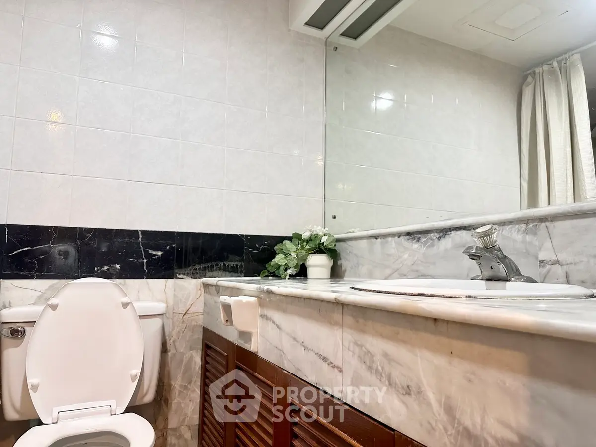 Elegant bathroom with marble countertop and modern fixtures in a stylish real estate property.