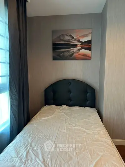 Cozy bedroom with single bed and scenic wall art, perfect for relaxation.