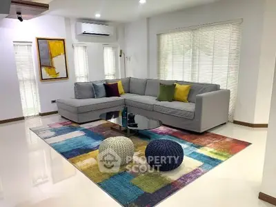 Spacious living room with modern sectional sofa and colorful rug