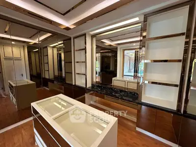 Luxurious walk-in closet with mirrored walls and elegant shelving