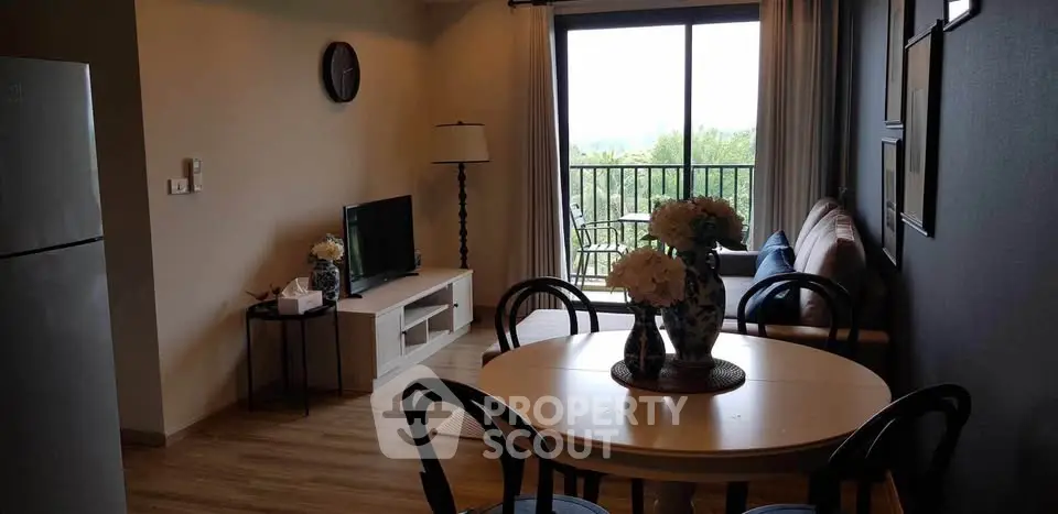 Charming living room with balcony view, elegant dining set, and cozy decor.