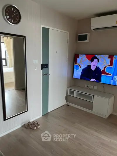 Modern living room with wall-mounted TV and air conditioning in a stylish apartment.