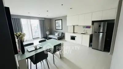 Modern open-plan living room and kitchen with sleek design and natural light.