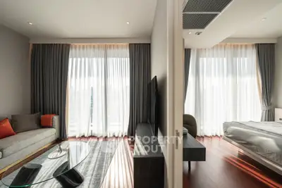 Modern apartment with spacious living room and bedroom, featuring large windows and elegant decor.