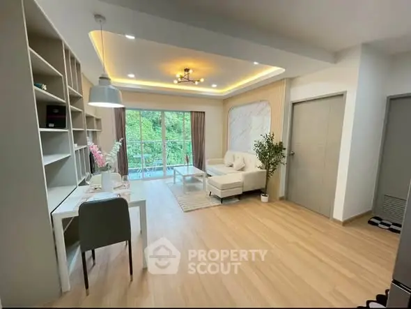 Modern living room with stylish decor and large windows overlooking greenery.