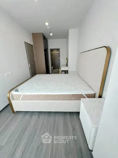 Spacious modern bedroom with elegant bed and sleek flooring
