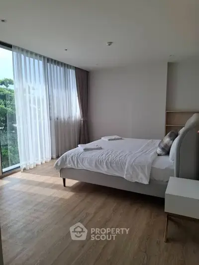 Spacious bedroom with large windows and elegant decor