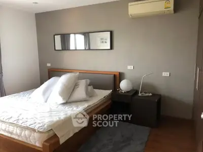 Modern bedroom with stylish decor and air conditioning, featuring a cozy bed and elegant furnishings.