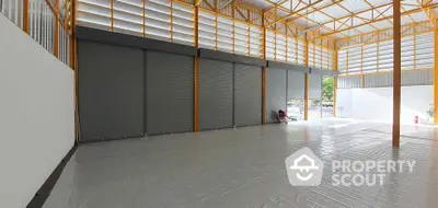 Spacious industrial warehouse with high ceilings and large roller doors