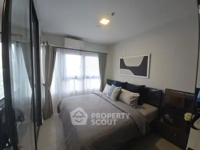 Cozy modern bedroom with large window and stylish decor in a contemporary apartment.