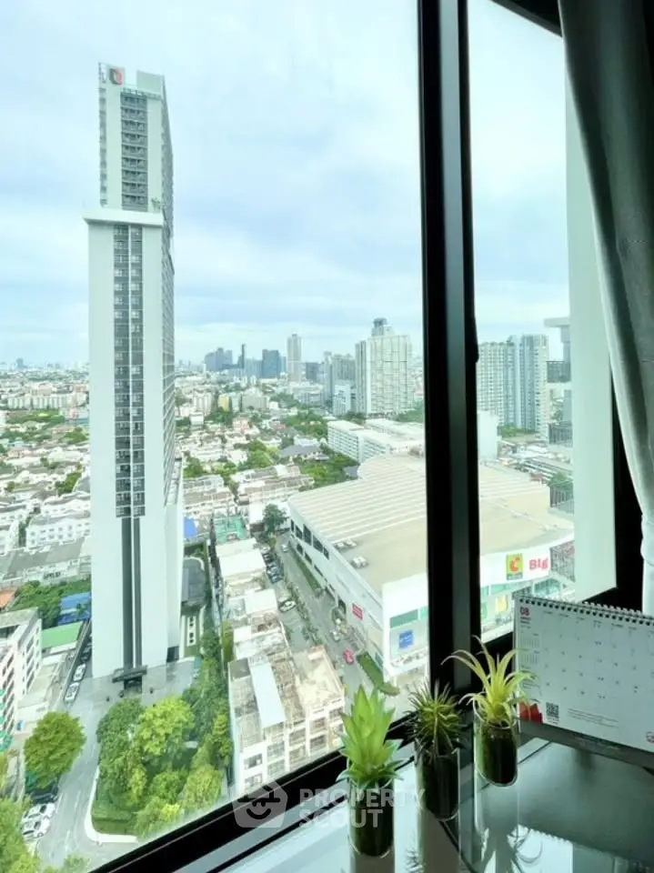 Stunning cityscape view from high-rise apartment window with modern decor.