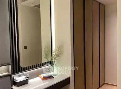 Modern bedroom with sleek wardrobe and elegant vanity mirror.