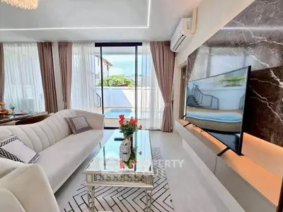 Luxurious living room with modern decor, large TV, and stunning outdoor view.