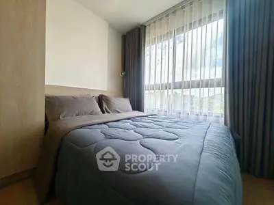 Cozy bedroom with large window and modern decor in a stylish apartment.