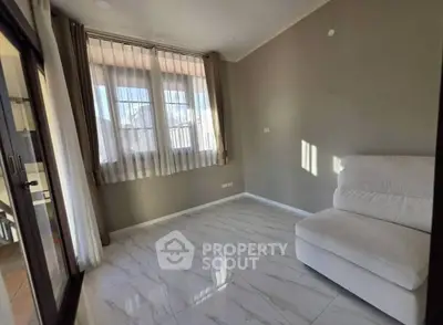 Bright and airy room with large windows and modern flooring, perfect for relaxation.