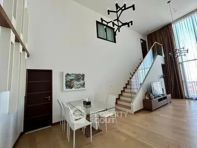 Spacious modern living room with high ceilings and elegant staircase