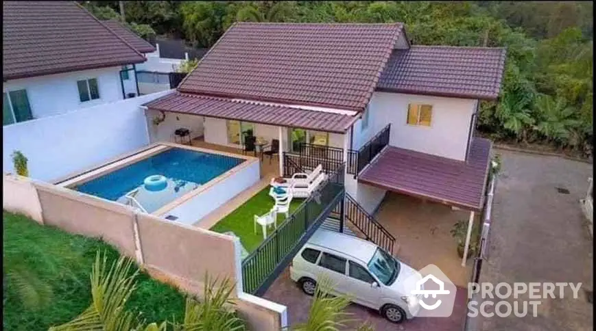 Stunning elevated home with pool and carport in lush green setting.