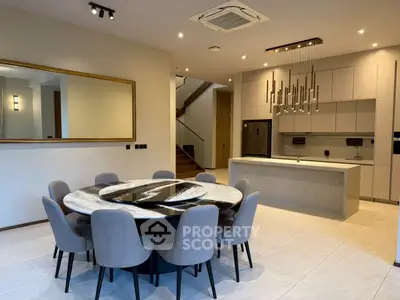 Luxurious open-plan kitchen and dining area with modern chandelier and elegant decor