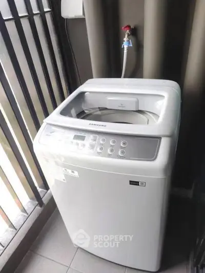 Modern washing machine on a balcony with sleek railing, perfect for urban living convenience.