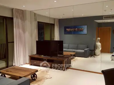 Stylish modern living room with mirrored wall and cozy furniture in a contemporary apartment.
