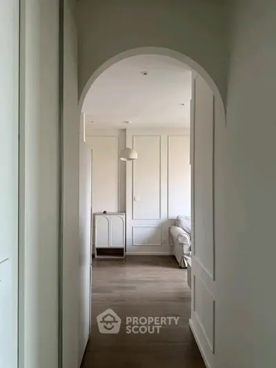 Elegant hallway leading to a cozy living room with modern decor and soft lighting.