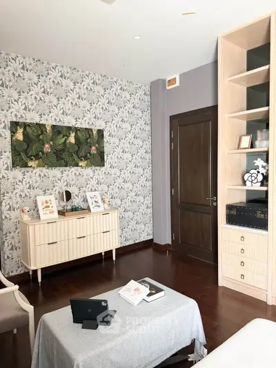 Charming living room with stylish wallpaper and elegant wooden furniture, perfect for cozy gatherings.