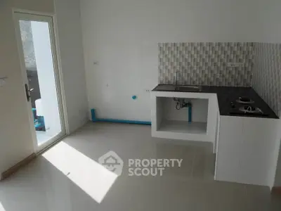 Modern minimalist kitchen with sleek countertops and ample natural light.