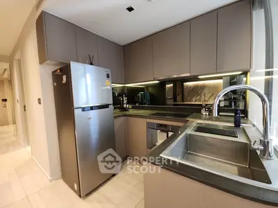Modern kitchen with sleek cabinetry and stainless steel appliances in a contemporary apartment.