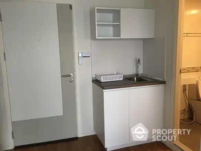 Compact studio apartment with kitchenette and bathroom, ideal for urban living.