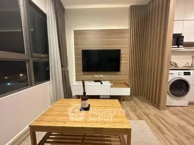Modern living room with wooden accents, featuring a wall-mounted TV and a washing machine in the open kitchen area.