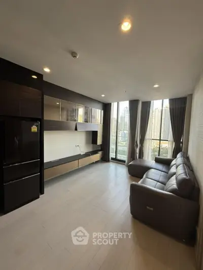 Modern living room with city view, sleek furniture, and large windows in a high-rise apartment.