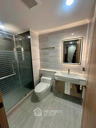Modern bathroom with sleek design, glass shower, and elegant fixtures in a contemporary apartment.