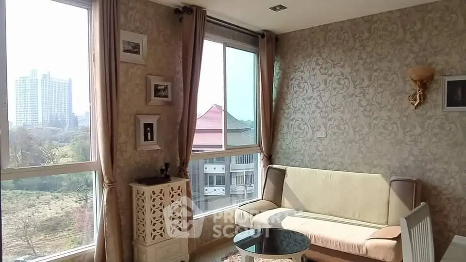 Charming living room with elegant wallpaper and large windows offering a scenic city view.