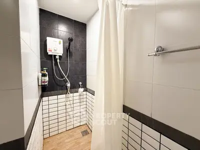 Modern bathroom with sleek black and white tiles and shower area
