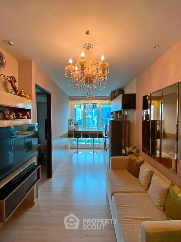 Luxurious living room with elegant chandelier and modern decor in high-rise apartment.