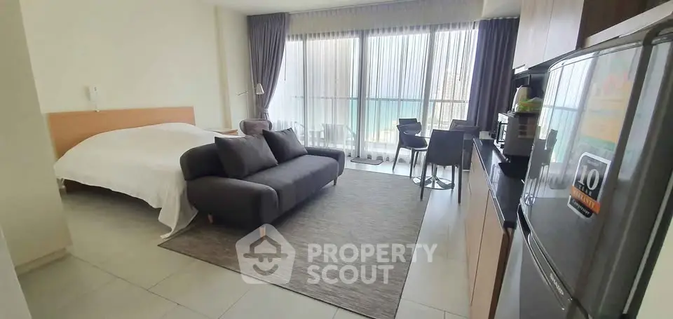 Modern studio apartment with cozy living area and balcony view
