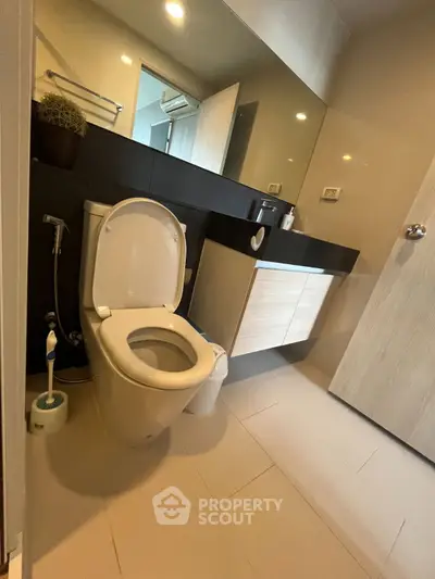 Modern bathroom with sleek fixtures and large mirror in a contemporary home.