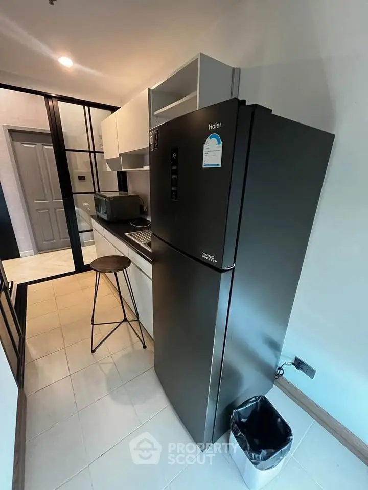Modern kitchen with sleek black fridge and minimalist design